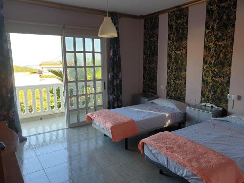 a bedroom with two beds and a large window at Casa Rural Fayna in Granadilla de Abona