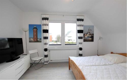 um quarto com uma cama, uma televisão e uma janela em Neuwerk em Cuxhaven