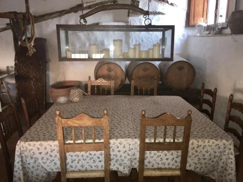 ein Esszimmer mit einem Tisch, Stühlen und Weinfässern in der Unterkunft La Casa Amarilla in Rubielos de Mora