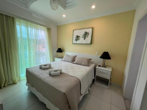 a bedroom with a bed with two towels on it at Hotel The Green Ecologic in Guarujá