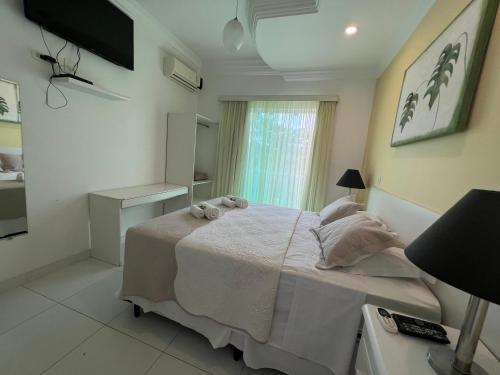 a bedroom with a large bed with towels on it at Hotel The Green Ecologic in Guarujá
