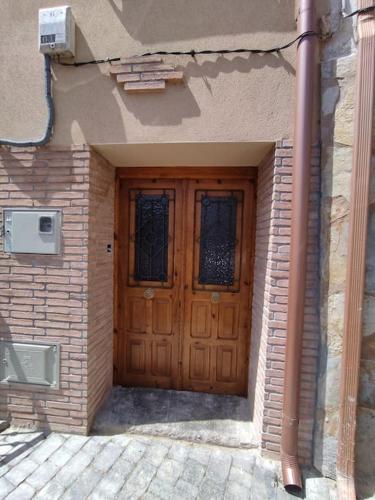 a wooden door on a building with a brick wall at La calma de Arnedillo in Arnedillo