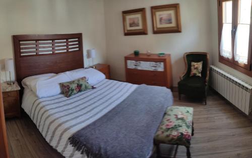 a bedroom with a large bed and a chair at La calma de Arnedillo in Arnedillo