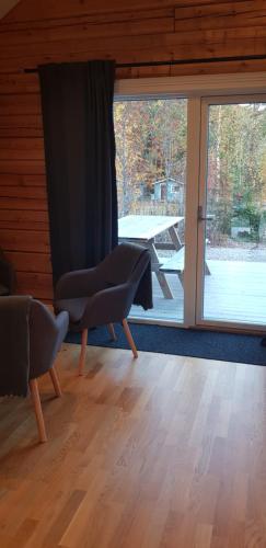 a living room with a chair and a large window at Ammeråns Fiskecamp in Hammarstrand