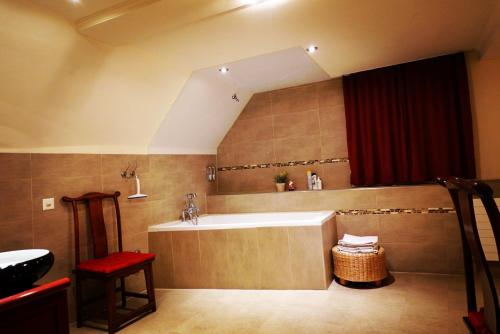 Hotel JiuDing في Hochdorf: حمام كبير مع حوض استحمام وستارة حمراء