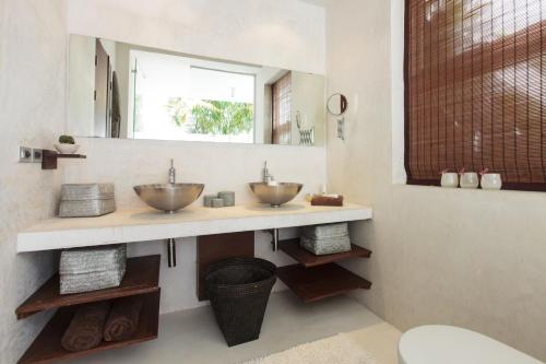 Un baño con dos lavabos y un espejo. en Villa Koru Samui, en Mae Nam