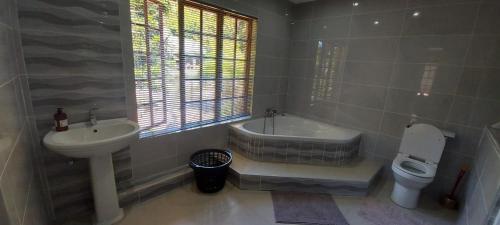 a bathroom with a tub and a sink and a toilet at The Court House- Ramsgate KZN in Ramsgate