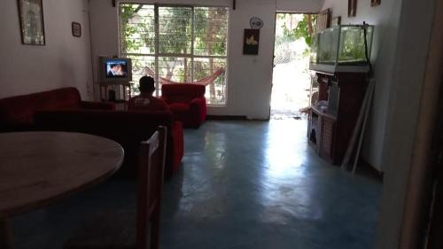 sala de estar con sofá rojo y TV en La casa del nenufar en Oaxaca de Juárez