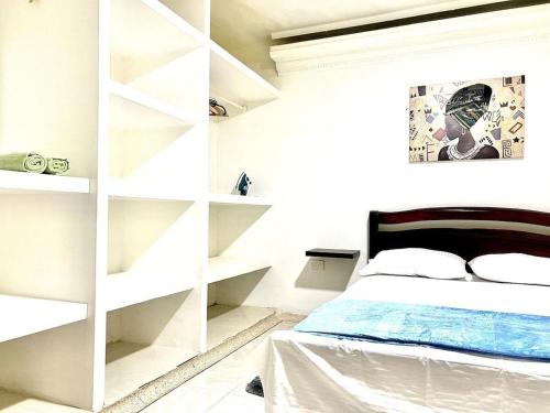 a bedroom with a white book shelf next to a bed at Apartamento Cerca al Complejo Deportivo in Valledupar