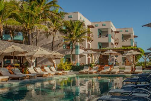 een zwembad met stoelen en parasols naast een gebouw bij Hotel Varandas Beach in Águas Belas