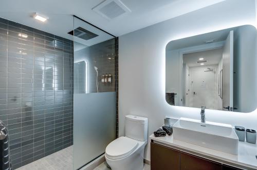a bathroom with a toilet and a sink and a mirror at High end studio yotel downtown L57 in Miami