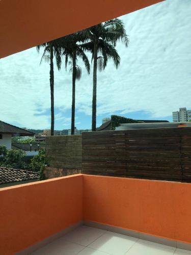 a balcony with palm trees in the background at HOTEL ENSEADA BEIRA MAR in Guarujá