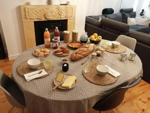 a table with food on it in a living room at Le logis d'Hestia in Billom