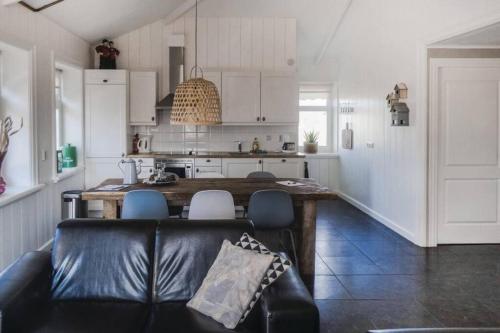 ein Wohnzimmer mit einem Sofa und einer Küche in der Unterkunft Logies De Hooiberg in Lutjewinkel