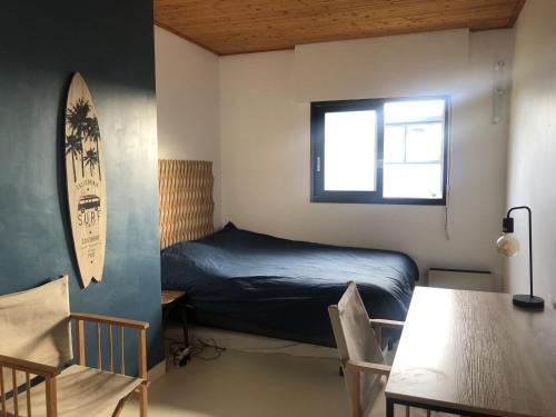 1 dormitorio con 1 cama, mesa y sillas en VILLA LES HORTENSIAS - proche de la plage, en Jard-sur-Mer
