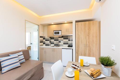 a kitchen and living room with a table and a couch at Theo Star Beach Hotel in Malia