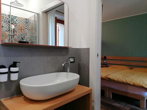 baño con lavabo blanco y cama en ALPINO B&B en Chiesa in Valmalenco