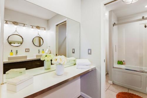 Baño blanco con lavabo y espejo en Desert Pool House: Sun, Swim, Sip & Stay, en Indio