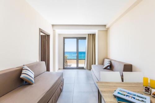 a living room with a couch and a view of the ocean at Theo Star Beach Hotel in Malia