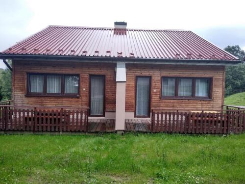 a small wooden house with a large wooden deck at Osrodek Wypoczynkowy " BIESZCZADY" in Myczkowce