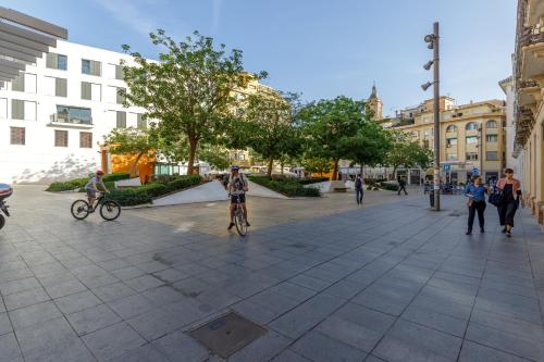 a person riding a bike on a street at H-A Hotel Trebol in Málaga