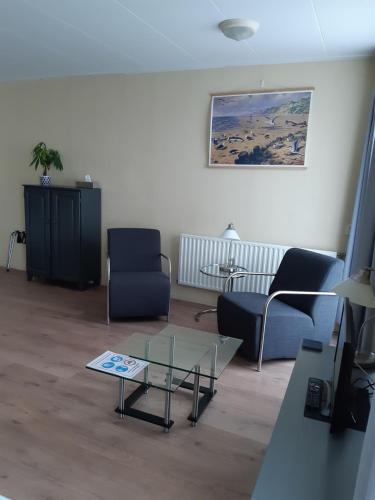 a living room with two chairs and a coffee table at Logement 'De witte klok' in Oude Bildtzijl