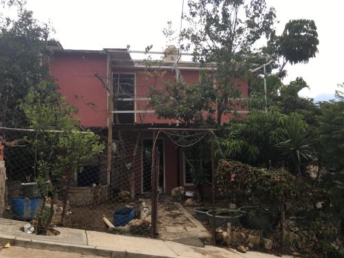 una casa roja con una valla delante en La casa del nenufar, en Oaxaca City
