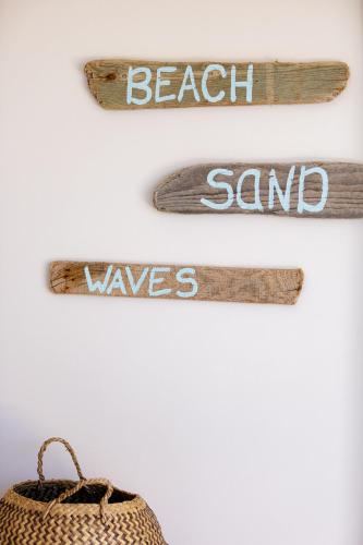 a wall with beach sand and waves signs and a basket at Theo Star Beach Hotel in Malia