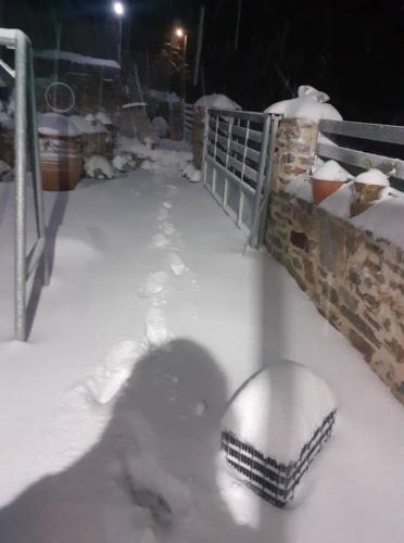 a snow covered walkway with a fence and a bowl of snow at MARINOS House WANDERN&ENTSPANNEN am Fusse des Psiloritis in Kamárai