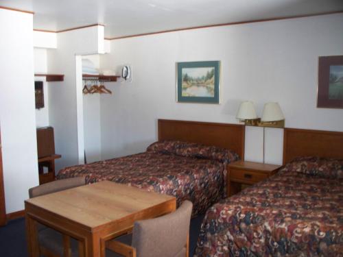 a hotel room with two beds and a table at Alpine Lodge in Davis