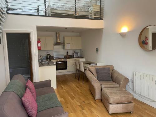 a living room with a couch and chairs and a kitchen at Rossendale Holiday Cottages & Spa in Rossendale