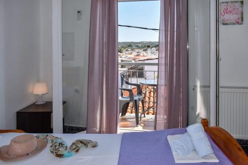 Schlafzimmer mit einem Bett und Blick auf einen Balkon in der Unterkunft Skiathos home with the best view in Skiathos-Stadt