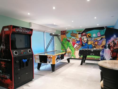 Una habitación con una consola de videojuegos y una mesa de ping pong. en Gîte de Brunemont, en Diéval
