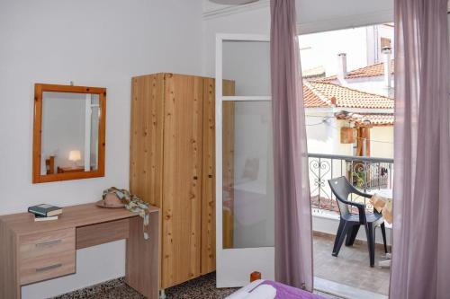 Schlafzimmer mit einem Schreibtisch und einem Spiegel sowie einem Balkon in der Unterkunft Skiathos home with the best view in Skiathos-Stadt