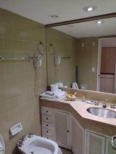 a bathroom with a sink and a toilet and a mirror at Departamento Corrientes Av. in Buenos Aires