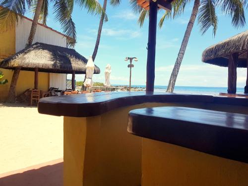 a table on the beach with palm trees and the ocean at Morro Beach Hotel in Morro de São Paulo