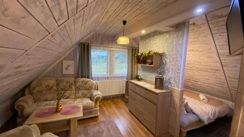 Zimmer mit einem Bett, einem Sofa und einem Fenster in der Unterkunft UROCZYSKO in Wisła