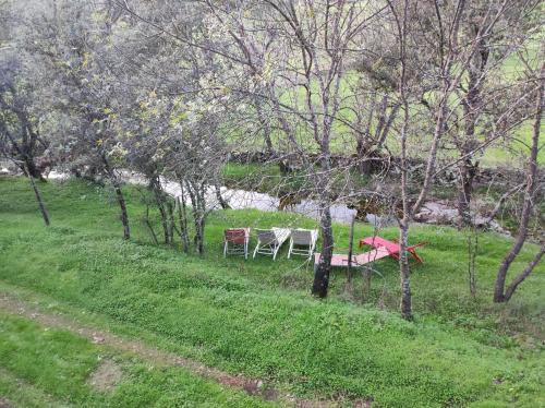two tables and chairs in a field with trees at Hotel Rural Finca Liceo in Mijares