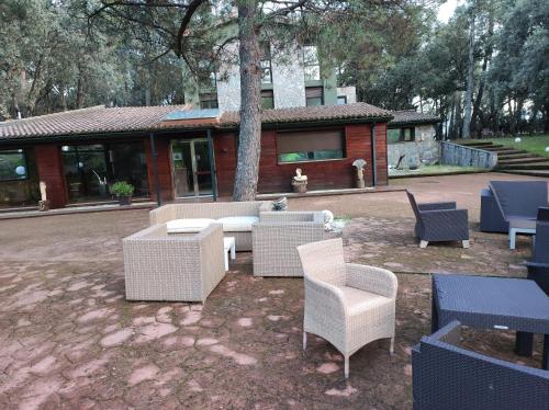 Hotel Rural Finca Liceo في Mijares: مجموعة من الكراسي والطاولات في الفناء