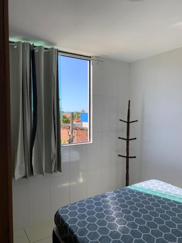 Schlafzimmer mit einem Bett und einem Fenster in der Unterkunft Maragogi Flat Residence in Maragogi