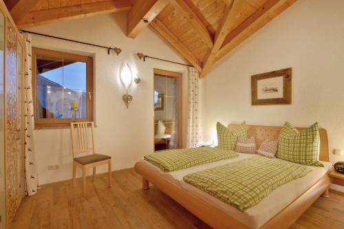 a bedroom with a bed with a chair and a window at Appartement Kugl in Fügen