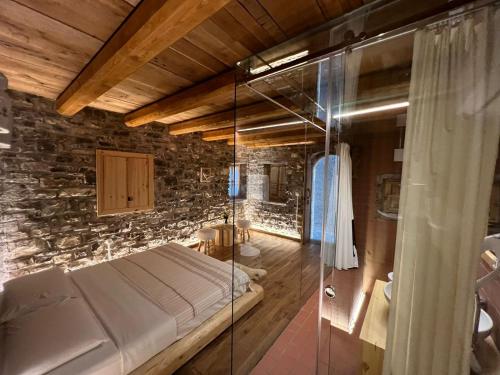 a bedroom with a bed and a glass shower at Mrizi i Zanave Agroturizëm in Lezhë