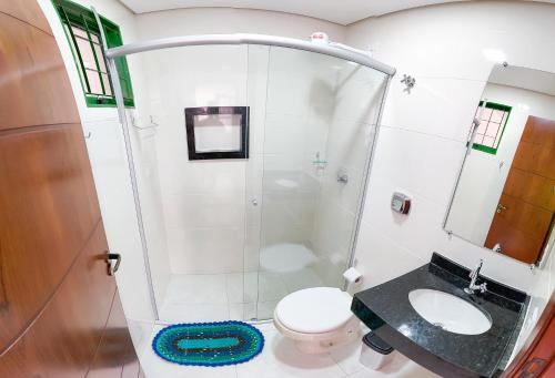a bathroom with a shower and a toilet and a sink at Apto com churrasq em Monte Castelo-Campo Grande MS in Campo Grande