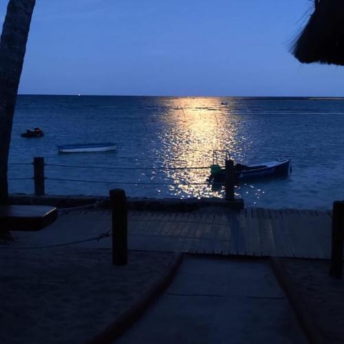 a view of the ocean with boats in the water at Morro Beach Hotel in Morro de São Paulo
