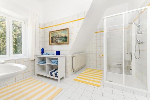 a bathroom with a tub and a shower and a sink at Seeappartements Eden in Pörtschach am Wörthersee
