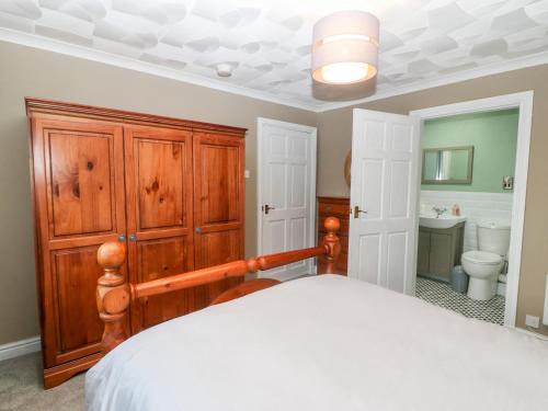 a bedroom with a large bed and a bathroom at Cedars in Holyhead