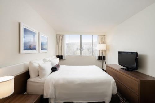 a hotel room with a bed and a tv at Hôtel 2170 Lincoln Downtown Montreal in Montréal