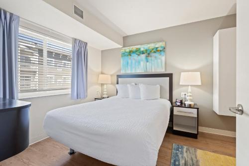 a bedroom with a large white bed and a window at WaterWalk- Kansas City- Overland Park in Overland Park