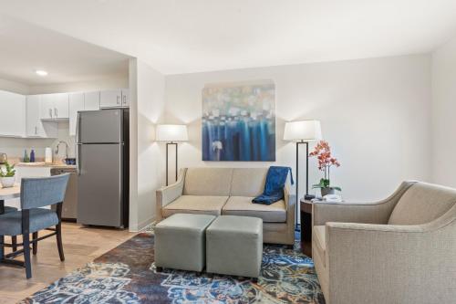 a living room with a couch and a kitchen at WaterWalk- Kansas City- Overland Park in Overland Park