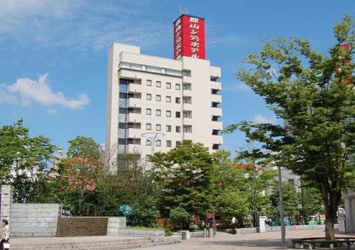 a white building with a red sign on top of it at Koriyama - Hotel / Vacation STAY 45300 in Koriyama